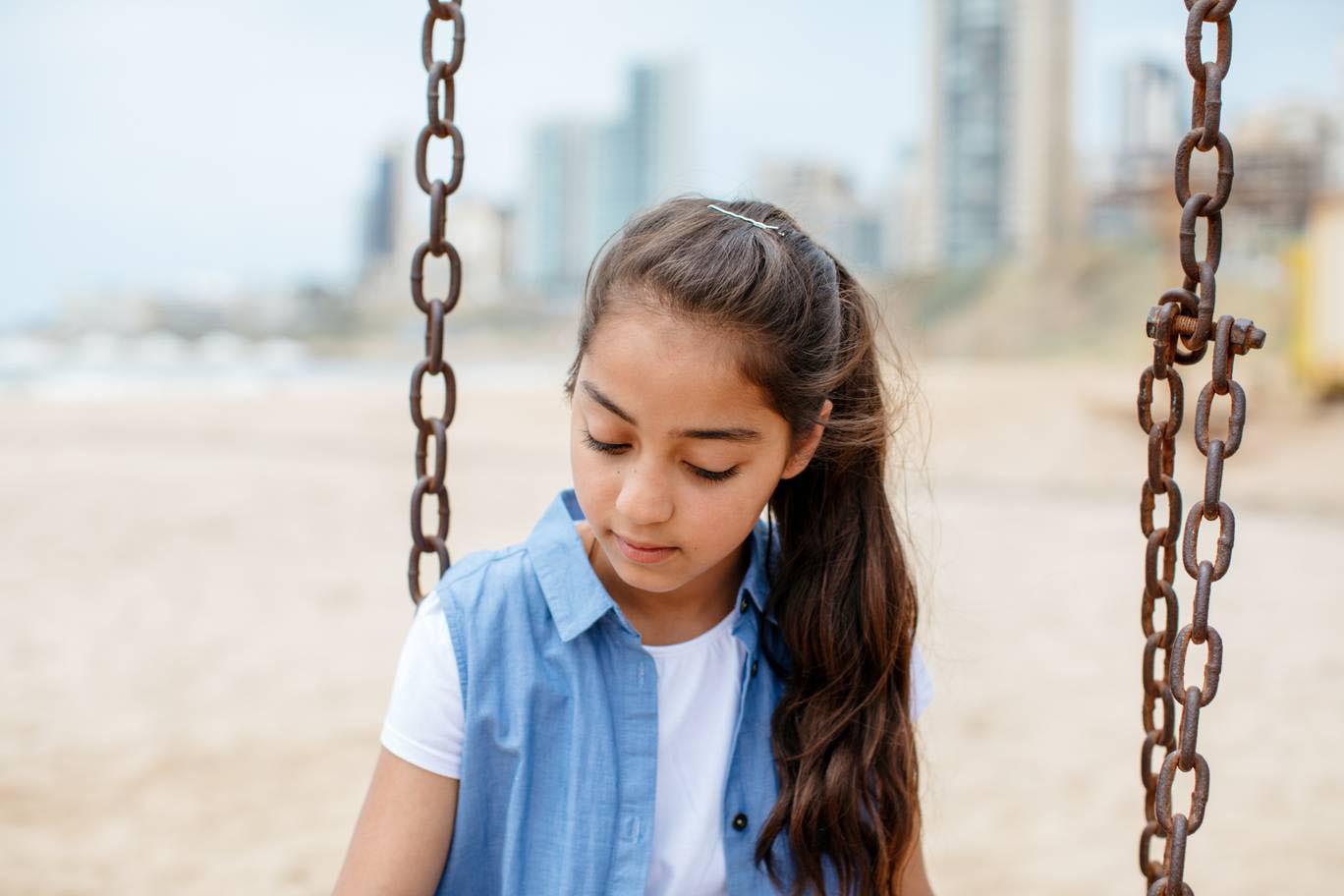At 11 years old, Sara could never have imagined becoming a refugee. Sitting on a swing in Beirut, she hopes for a better future built on a good education and psychosocial support made possible by EAA and UNRWA - Photo by Paddy Dowling