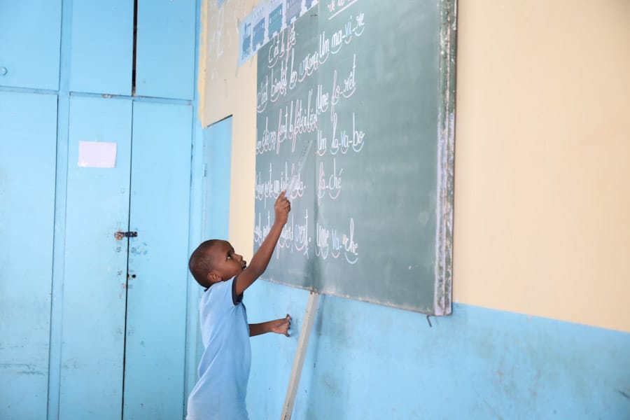 Little boy writing on chalkboard