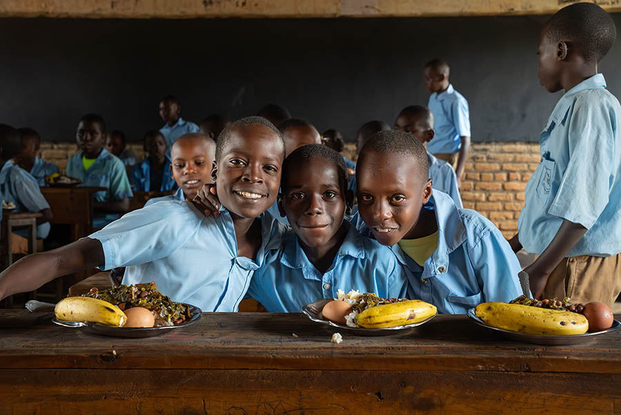 Boys in classroom, eating their lunch, Rwanda