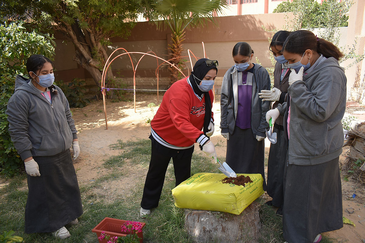 Enas Younis showing students how to mix soil for planting.  Photo: © UNICEF/Egypt