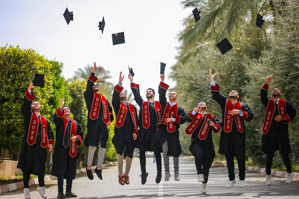 Graduating students throwing their caps in the air.