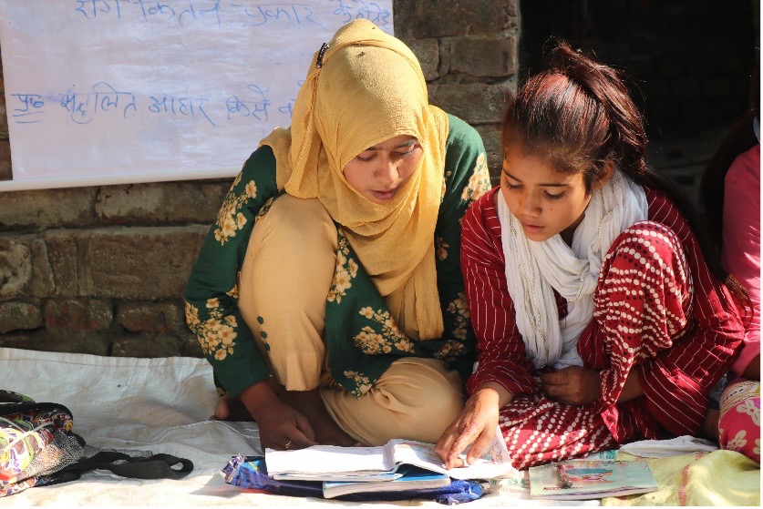 In the Digital School Program, two girls sit together as they read.