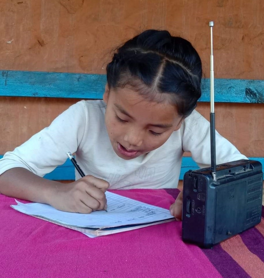Student listening to her lessons on the radio during COVID pandemic